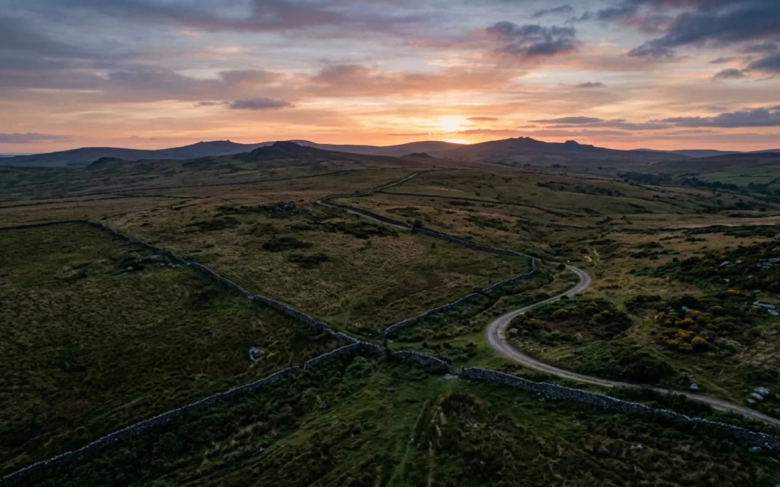 Aerial view of open Dartmoor grassland and dry stone walls at dusk, the kind of ground covered on a search flight